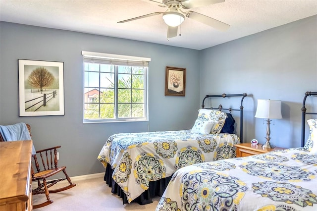 carpeted bedroom with ceiling fan and a textured ceiling