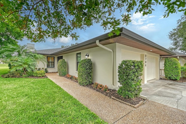 view of side of property featuring a garage and a lawn