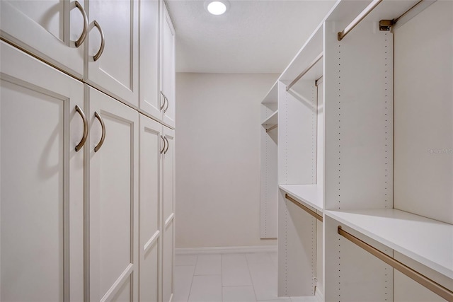 walk in closet with light tile flooring