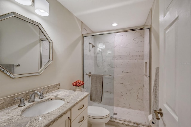 bathroom featuring vanity, toilet, and a shower with door