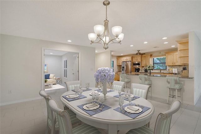 tiled dining space with sink and a chandelier