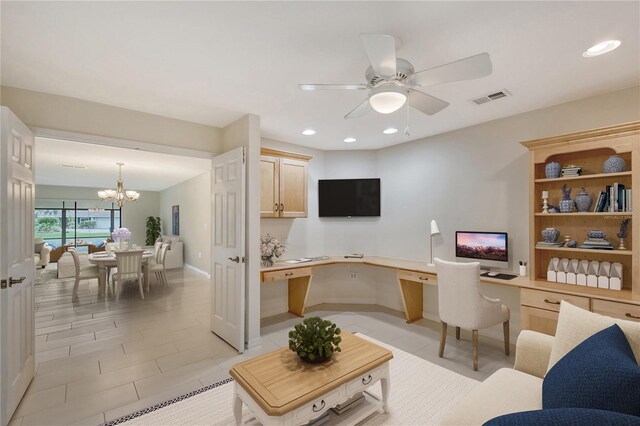 tiled home office with ceiling fan with notable chandelier and built in desk