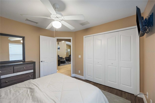 bedroom featuring hardwood / wood-style floors, a closet, and ceiling fan