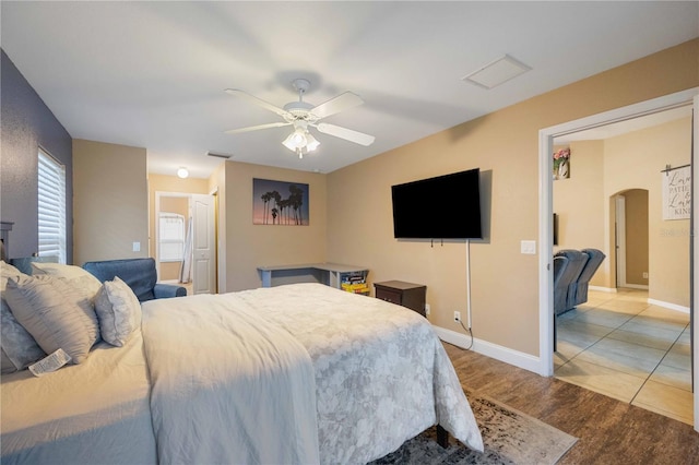 tiled bedroom featuring ceiling fan