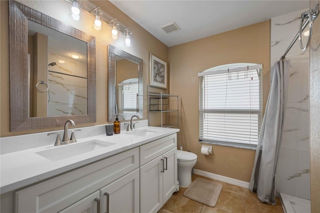 bathroom featuring tile floors, toilet, and dual bowl vanity