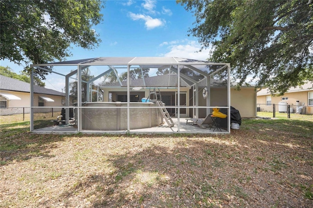 rear view of house featuring a patio, glass enclosure, and a fenced in pool