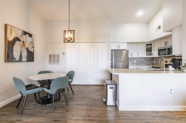 kitchen with wood-type flooring, tasteful backsplash, and appliances with stainless steel finishes