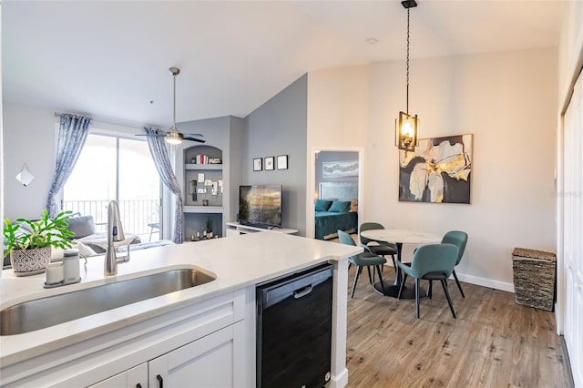 kitchen featuring light hardwood / wood-style floors, dishwasher, pendant lighting, sink, and white cabinets