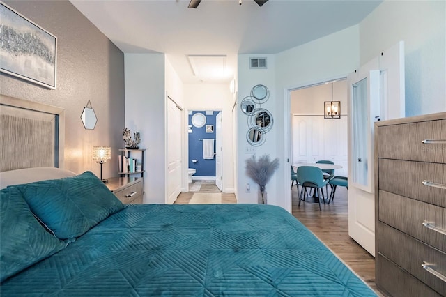 bedroom featuring ceiling fan, connected bathroom, and hardwood / wood-style flooring