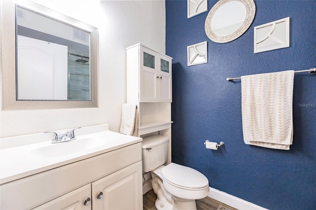 bathroom with wood-type flooring, toilet, and vanity