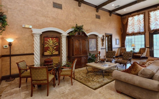 living room featuring a high ceiling, beam ceiling, light tile flooring, and decorative columns