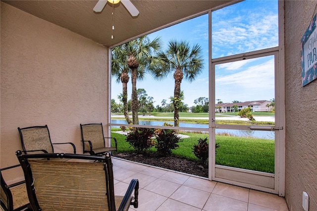 sunroom with a water view and ceiling fan