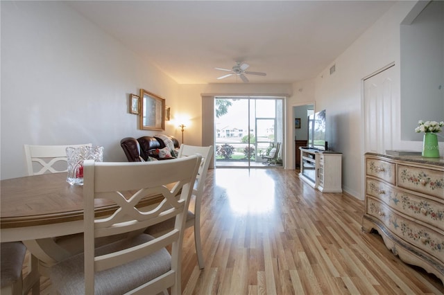 dining space with ceiling fan and light hardwood / wood-style flooring