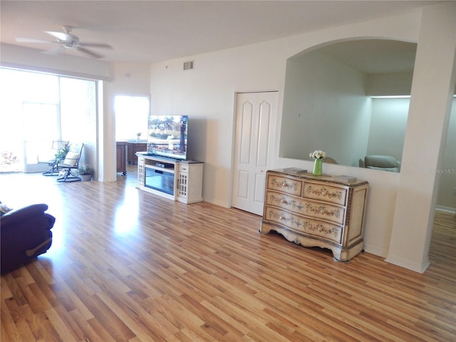 living room with ceiling fan and light wood-type flooring