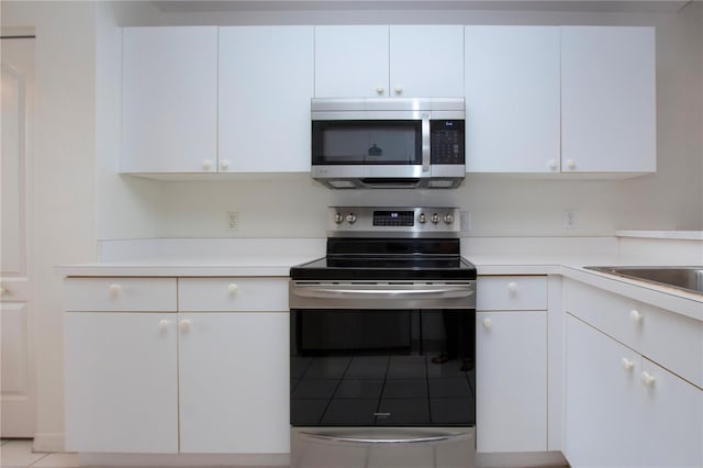 kitchen featuring stainless steel appliances and white cabinets