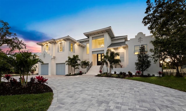 view of front of house featuring a garage, stucco siding, and decorative driveway