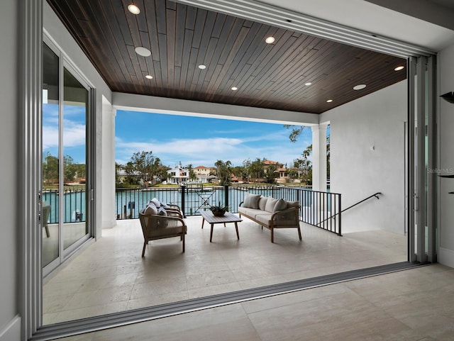 view of patio / terrace with a balcony, a water view, and outdoor lounge area
