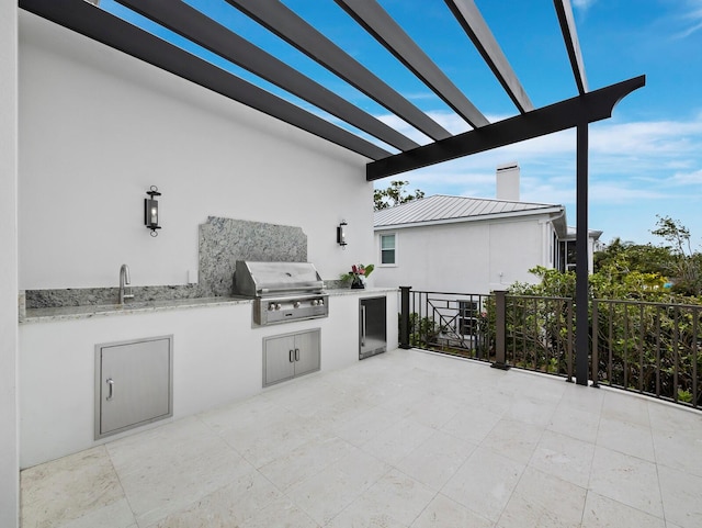 view of patio / terrace with grilling area, exterior kitchen, a pergola, fence, and a sink