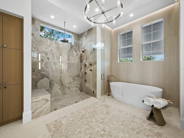 full bath featuring a chandelier, a marble finish shower, a freestanding bath, and recessed lighting