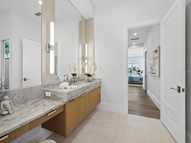 bathroom featuring connected bathroom, vanity, recessed lighting, and baseboards