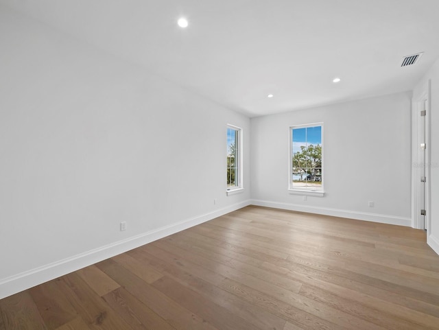unfurnished room with baseboards, light wood-style flooring, and recessed lighting
