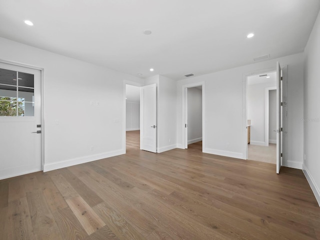 unfurnished room featuring wood finished floors, recessed lighting, and baseboards