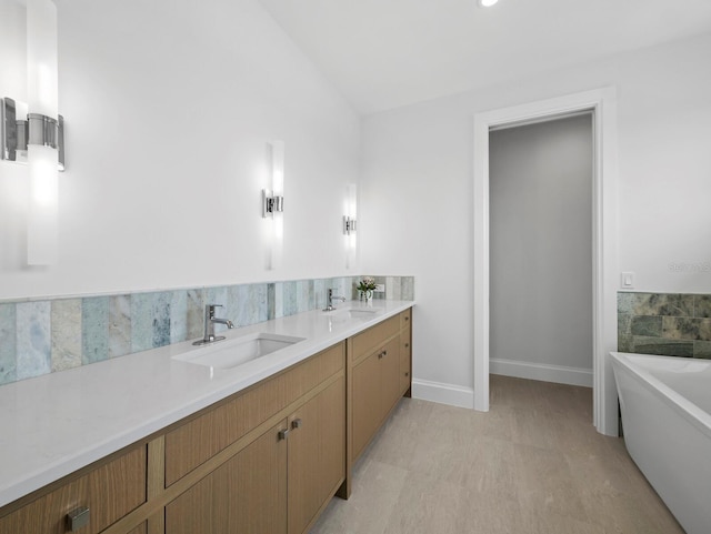 bathroom featuring a soaking tub, baseboards, and double vanity