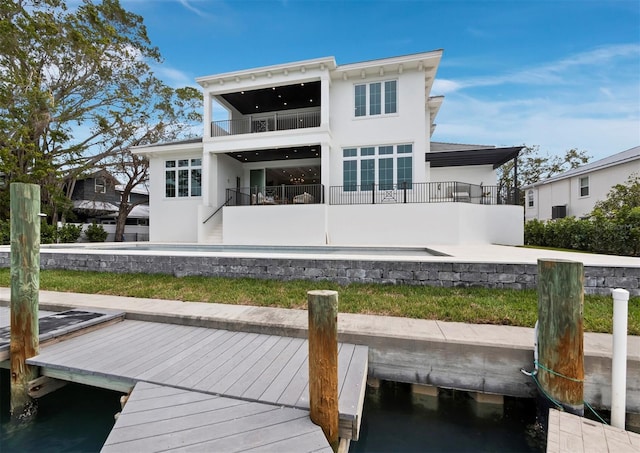 back of property with a balcony and stucco siding