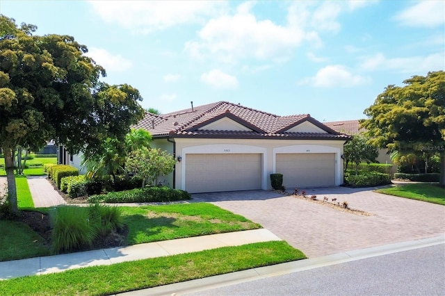 mediterranean / spanish-style home featuring a garage and a front lawn