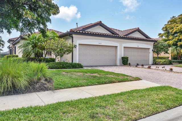 mediterranean / spanish-style house featuring a front yard and a garage