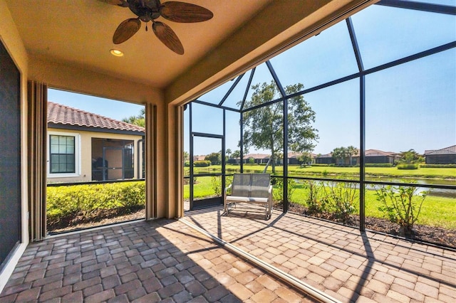 unfurnished sunroom featuring ceiling fan