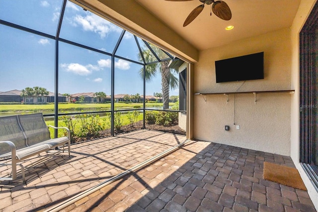 unfurnished sunroom with ceiling fan