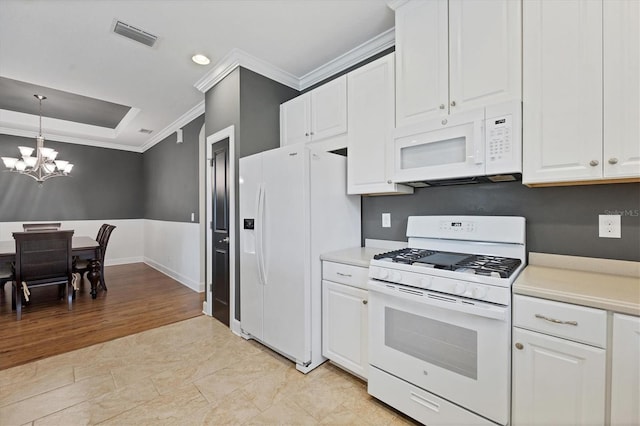 kitchen featuring white appliances, light tile flooring, pendant lighting, a notable chandelier, and white cabinetry