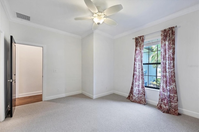 empty room featuring a healthy amount of sunlight, ornamental molding, carpet floors, and ceiling fan