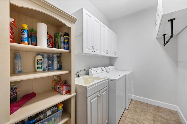 laundry area featuring sink, washing machine and clothes dryer, cabinets, and light tile floors