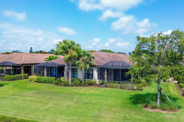 back of house featuring a lanai and a yard