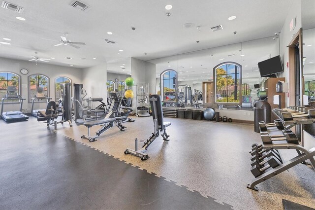 gym featuring a textured ceiling and ceiling fan