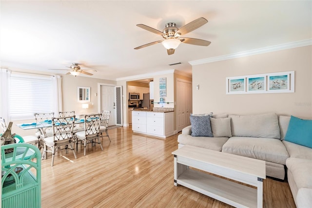 living room featuring ceiling fan, light hardwood / wood-style floors, and crown molding