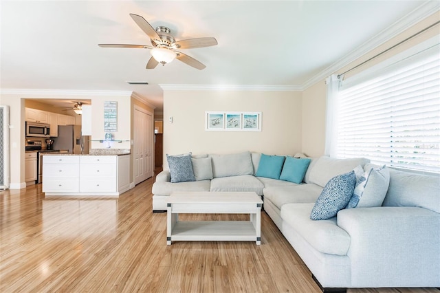 living room featuring ceiling fan, light hardwood / wood-style floors, and crown molding