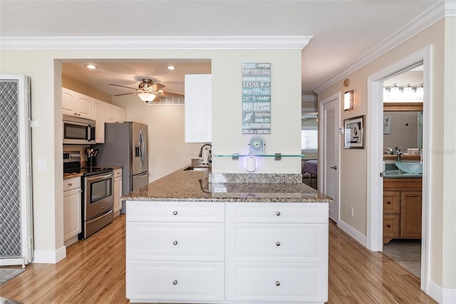 kitchen featuring light hardwood / wood-style floors, appliances with stainless steel finishes, kitchen peninsula, sink, and ceiling fan