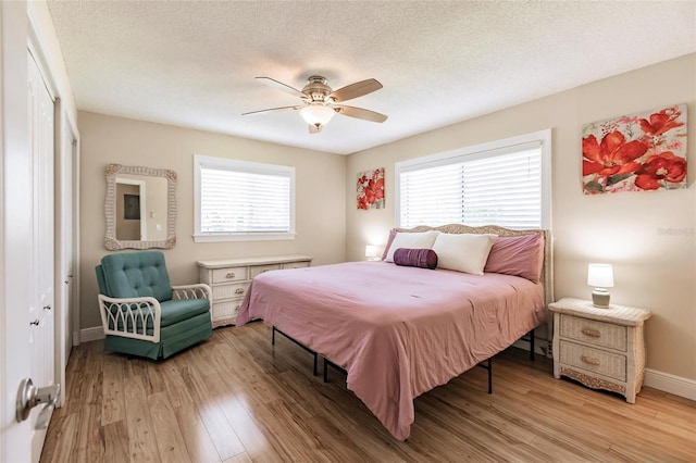 bedroom featuring ceiling fan, a closet, hardwood / wood-style flooring, and a textured ceiling