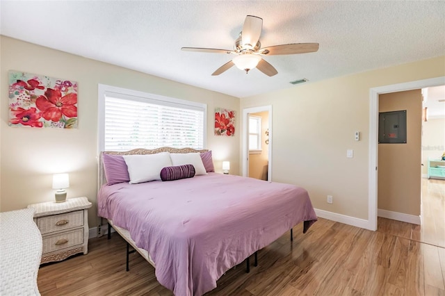 bedroom featuring a textured ceiling, wood-type flooring, and ceiling fan