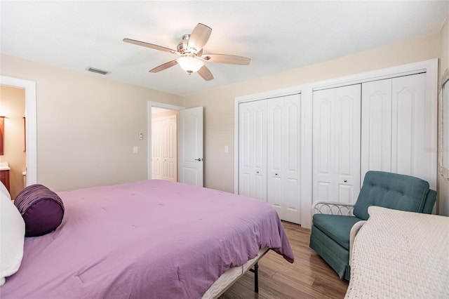 bedroom featuring two closets, ceiling fan, and light wood-type flooring