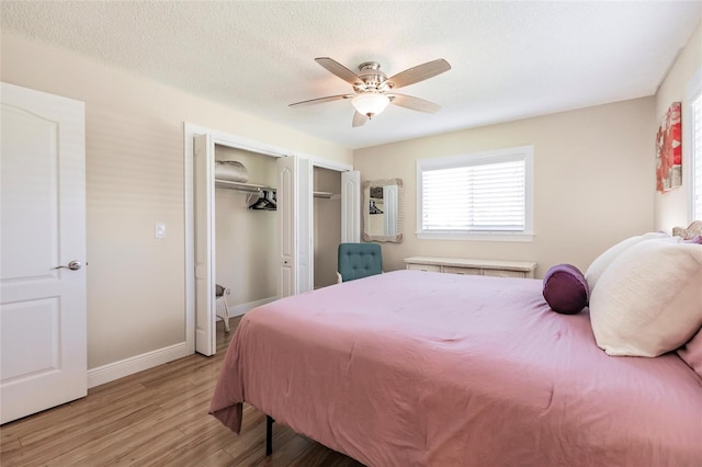 bedroom with hardwood / wood-style floors, ceiling fan, and a textured ceiling