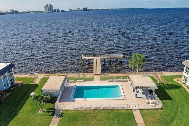 view of pool with a lawn and a water view