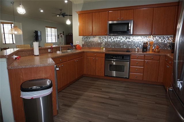 kitchen with ceiling fan, dark wood-type flooring, tasteful backsplash, kitchen peninsula, and appliances with stainless steel finishes