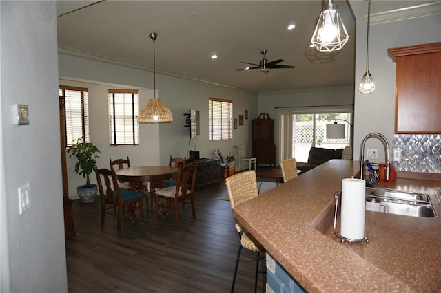 kitchen with ornamental molding, ceiling fan, dark wood-type flooring, sink, and pendant lighting