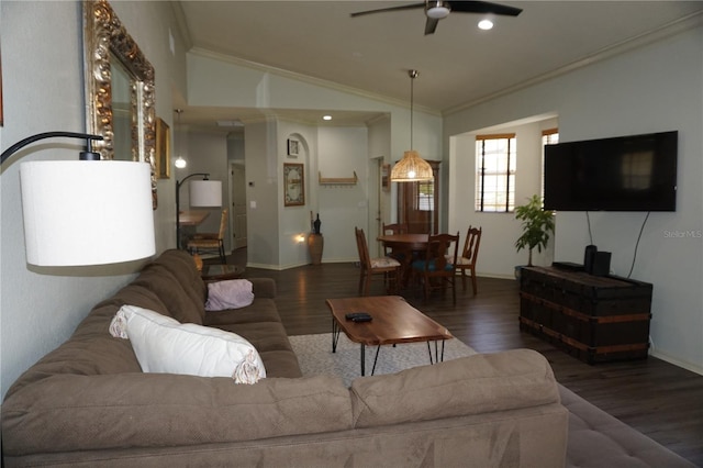 living room with ceiling fan, dark hardwood / wood-style flooring, ornamental molding, and vaulted ceiling