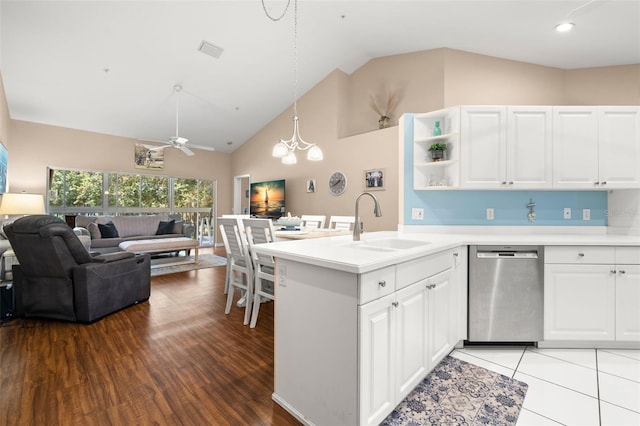 kitchen featuring sink, decorative light fixtures, stainless steel dishwasher, ceiling fan with notable chandelier, and white cabinets