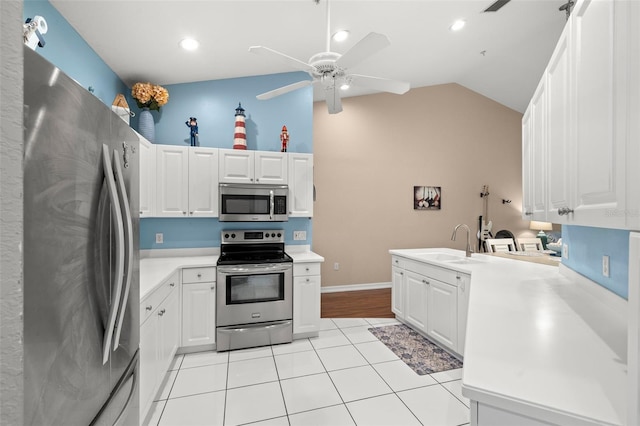 kitchen with white cabinetry, appliances with stainless steel finishes, sink, and lofted ceiling